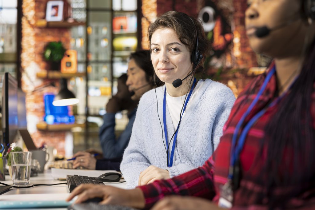 Portrait of cheerful call center manager evaluating company intern performance